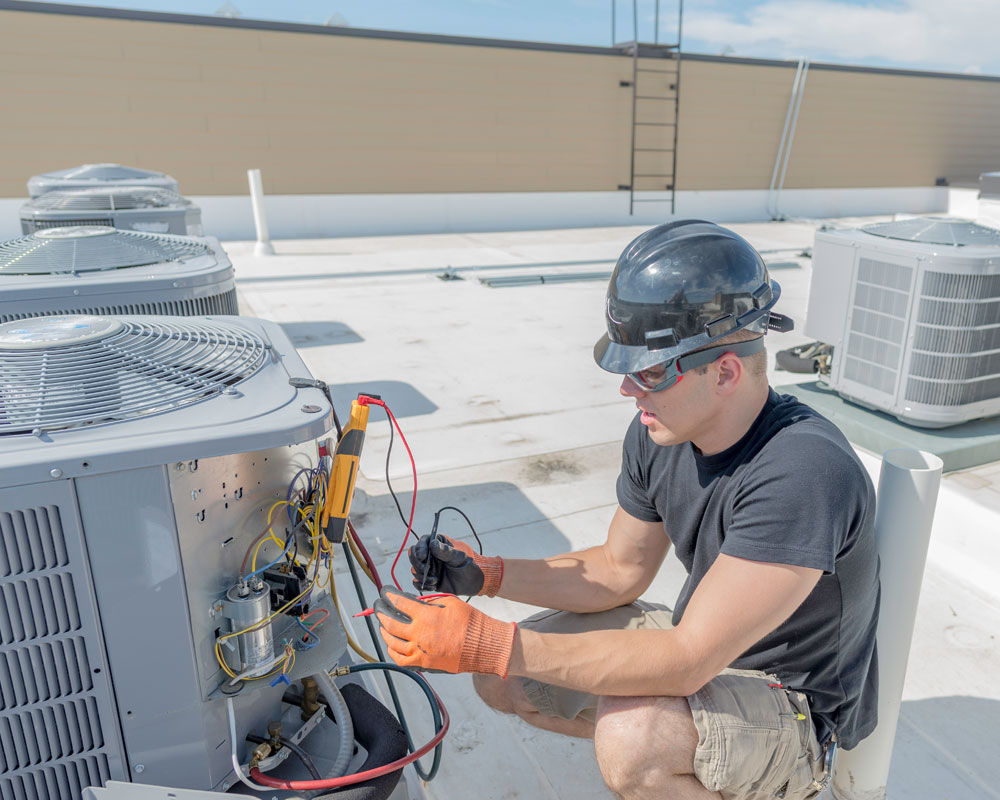 HVAC Solutions technician servicing a rooftop unit on a Spanish-style home